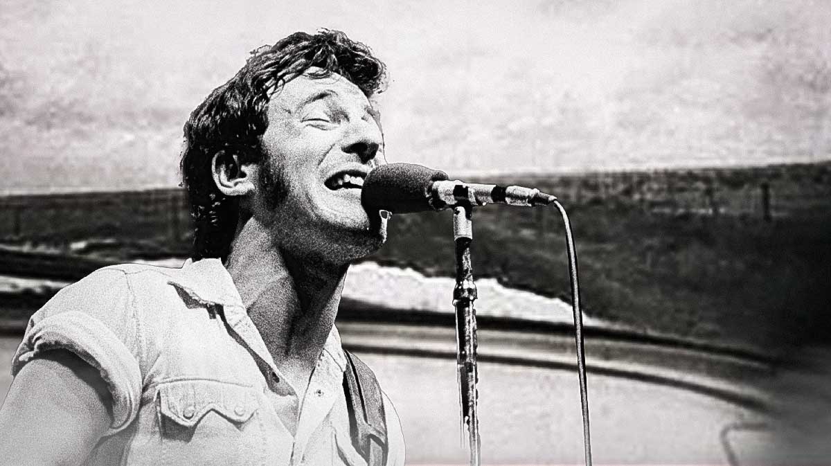 Bruce Springsteen with Nebraska album art behind him.