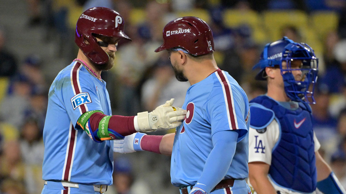 Philadelphia Phillies designated hitter Kyle Schwarber (12) is congratulated by first baseman Bryce Harper (3) after hitting a solo home run in the fourth inning against the Los Angeles Dodgers of game three of the NLDS during the 2025 MLB playoffs at Dodger Stadium.