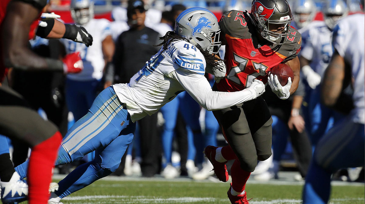 Tampa Bay Buccaneers running back Doug Martin (22) runs with the ball as Detroit Lions linebacker Jalen Reeves-Maybin (44) tackles during the first half at Raymond James Stadium.