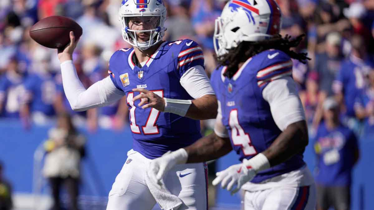 Buffalo Bills quarterback Josh Allen looks at running back James Cook as he launches a short pass to him during second half action of the Bills home game against the New Orleans Saints in Orchard Park