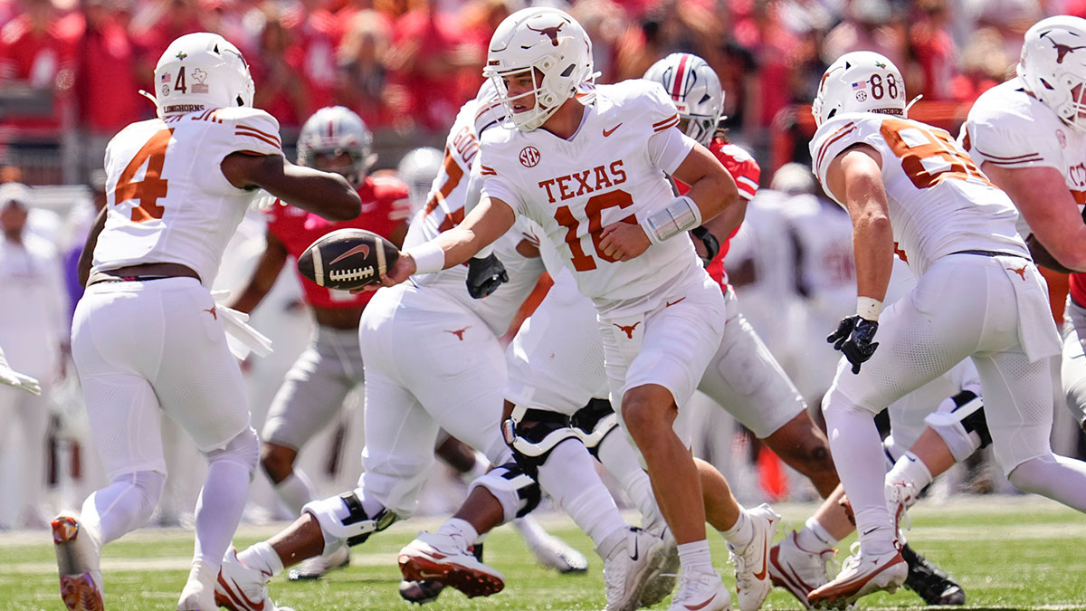 Texas Longhorns quarterback Arch Manning (16) hands off to running back CJ Baxter (4) during the NCAA football game against the Ohio State Buckeyes at Ohio Stadium on Aug. 30, 2025.