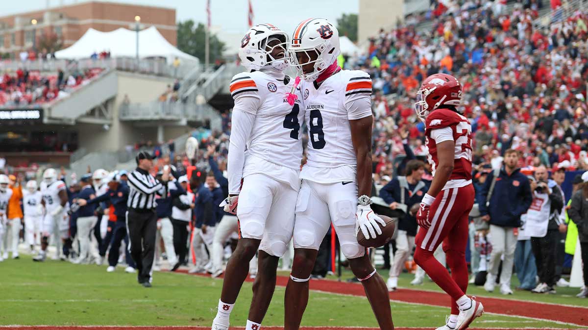 Auburn Tigers wide receiver Cam Coleman (8) celebrates with wide receiver Malcolm Simmons (4) after scoring a touchdown defended by Arkansas Razorbacks defensive back Julian Neal (23) during the first quarter at Donald W. Reynolds Razorback Stadium.