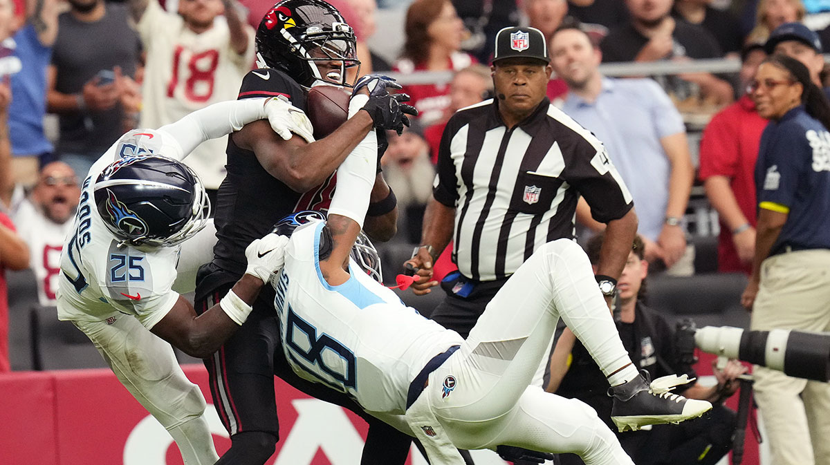 Arizona Cardinals receiver Marvin Harrison Jr. (18) makes a first-down catch over Tennessee Titans defenders Jalyn Armour-Davis (18) and Xavier Woods (25).