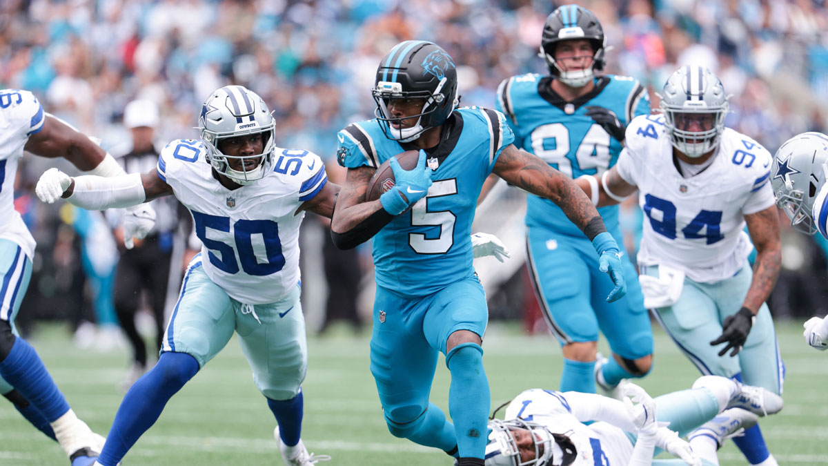 Carolina Panthers running back Rico Dowdle (5) runs with the ball while getting pressured by Dallas Cowboys linebacker Shemar James (50) during the second half at Bank of America Stadium.