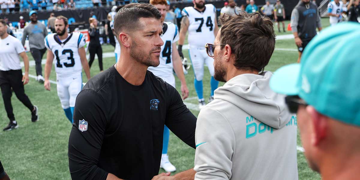 Carolina Panthers head coach Dave Canales shakes hands with Miami Dolphins head coach Mike McDaniel following the game at Bank of America Stadium.