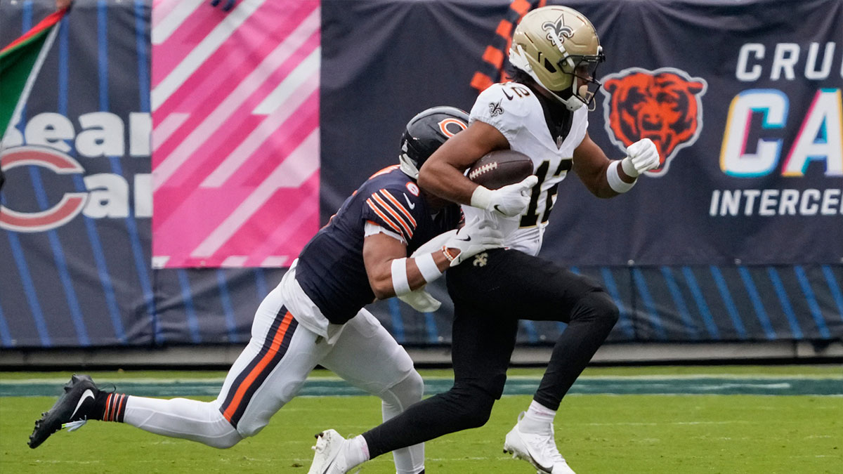 New Orleans Saints wide receiver Chris Olave (12) runs with the ball after making a catch against Chicago Bears cornerback Kyler Gordon (6) during the first half at Soldier Field. 