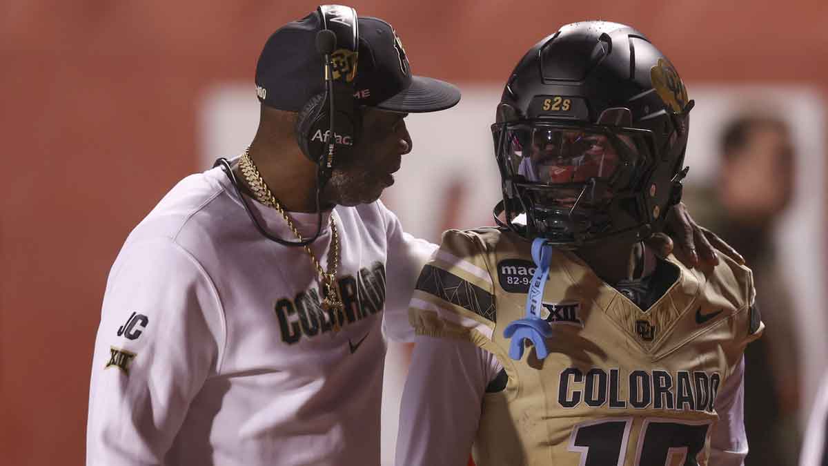 Colorado Buffaloes head coach Deion Sanders speaks with Colorado Buffaloes wide receiver Isaiah Hardge (17) before the game against the Utah Utes at Rice-Eccles Stadium.