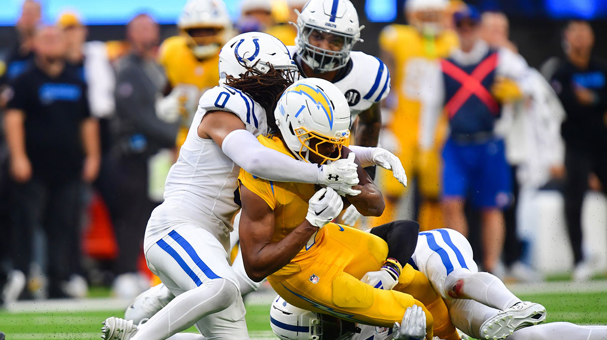 Indianapolis Colts safety Cam Bynum (0) brings down Los Angeles Chargers wide receiver Quentin Johnston (1) in the second half at SoFi Stadium.