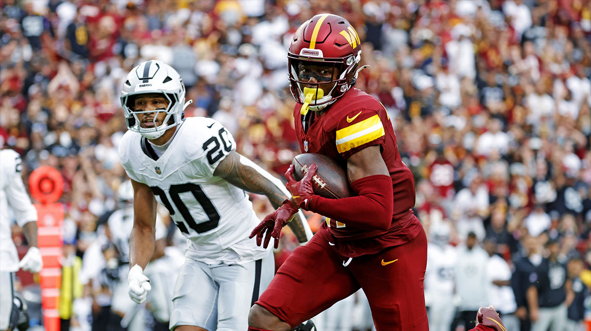 Washington Commanders wide receiver Terry McLaurin (17) runs the ball during the second half as Las Vegas Raiders safety Isaiah Pola-Mao (20) defends at Northwest Stadium.