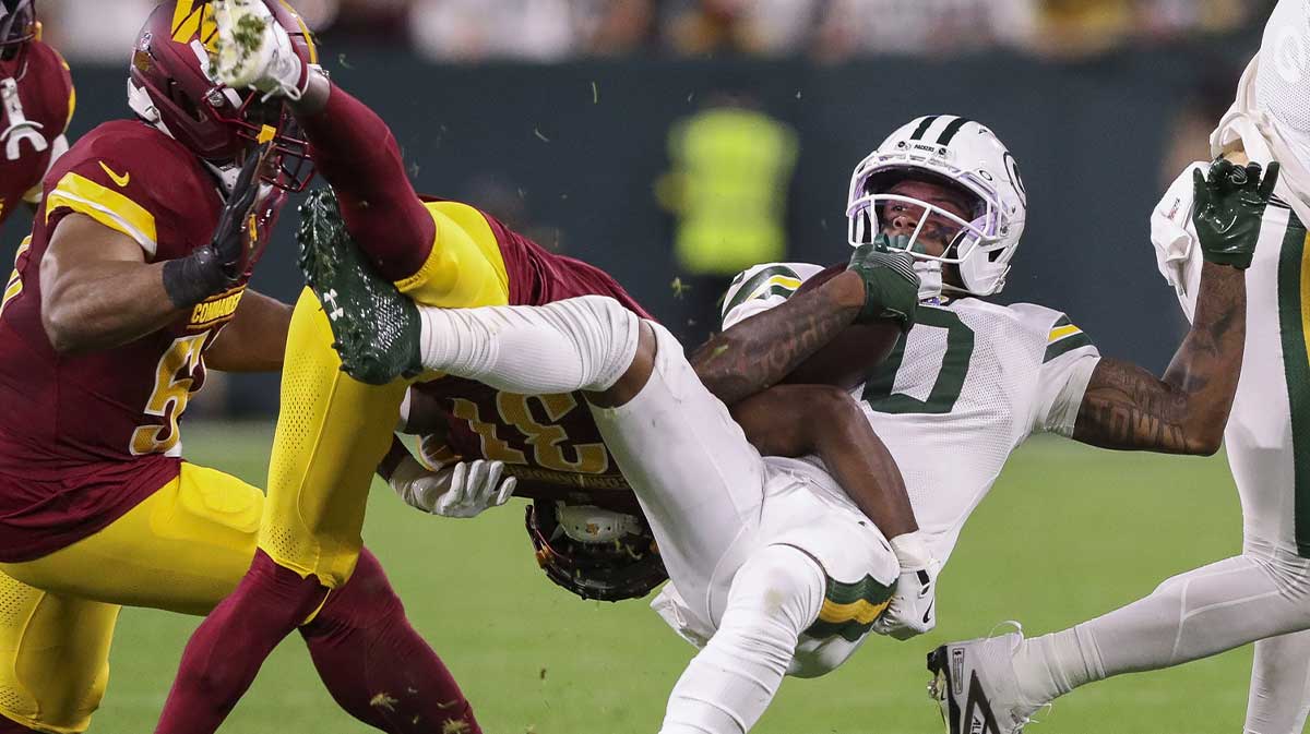 Green Bay Packers wide receiver Matthew Golden (0) is tackled by Washington Commanders cornerback Jonathan Jones (31) at Lambeau Field.