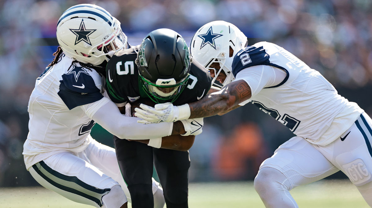New York Jets wide receiver Garrett Wilson (5) is tackled by Dallas Cowboys cornerback Trevon Diggs (7) and safety Juanyeh Thomas (2) during the first half at MetLife Stadium.