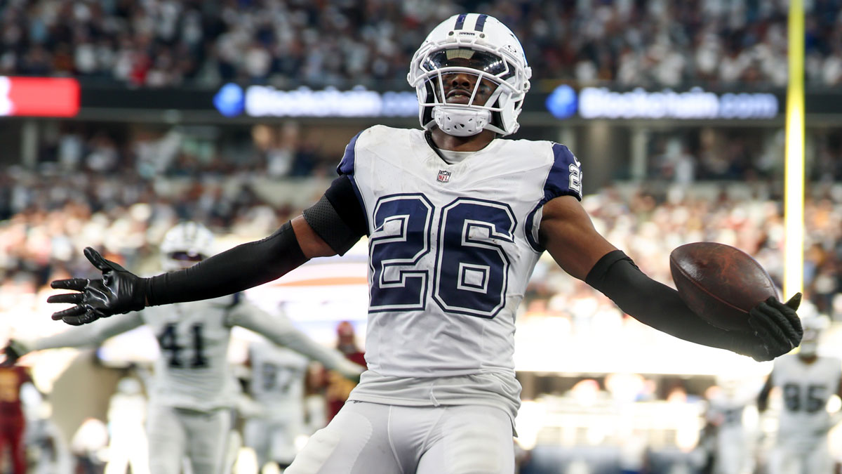 Dallas Cowboys cornerback Daron Bland (26) carries the ball after an interception for a touchdown against the Washington Commanders during the third quarter of the game at AT&T Stadium.