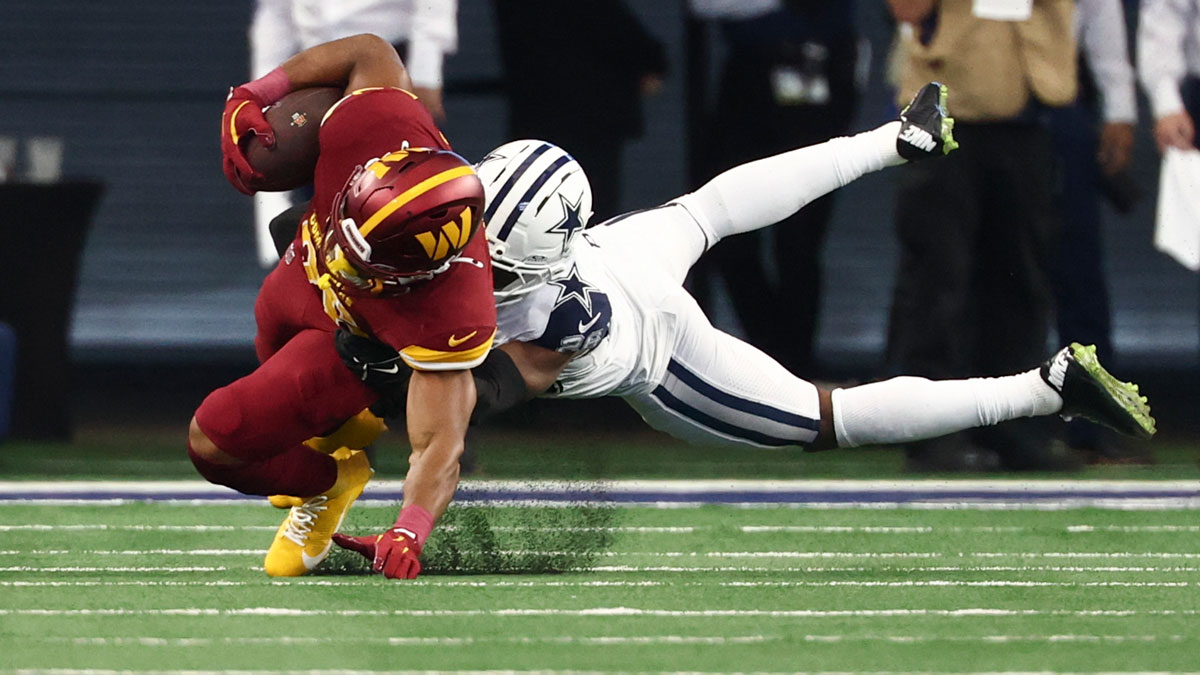 Dallas Cowboys cornerback Daron Bland (26) tackles Washington Commanders running back Jeremy McNichols (26) during the second quarter of the game at AT&T Stadium. Mandatory Credit: Kevin Jairaj-Imagn Images