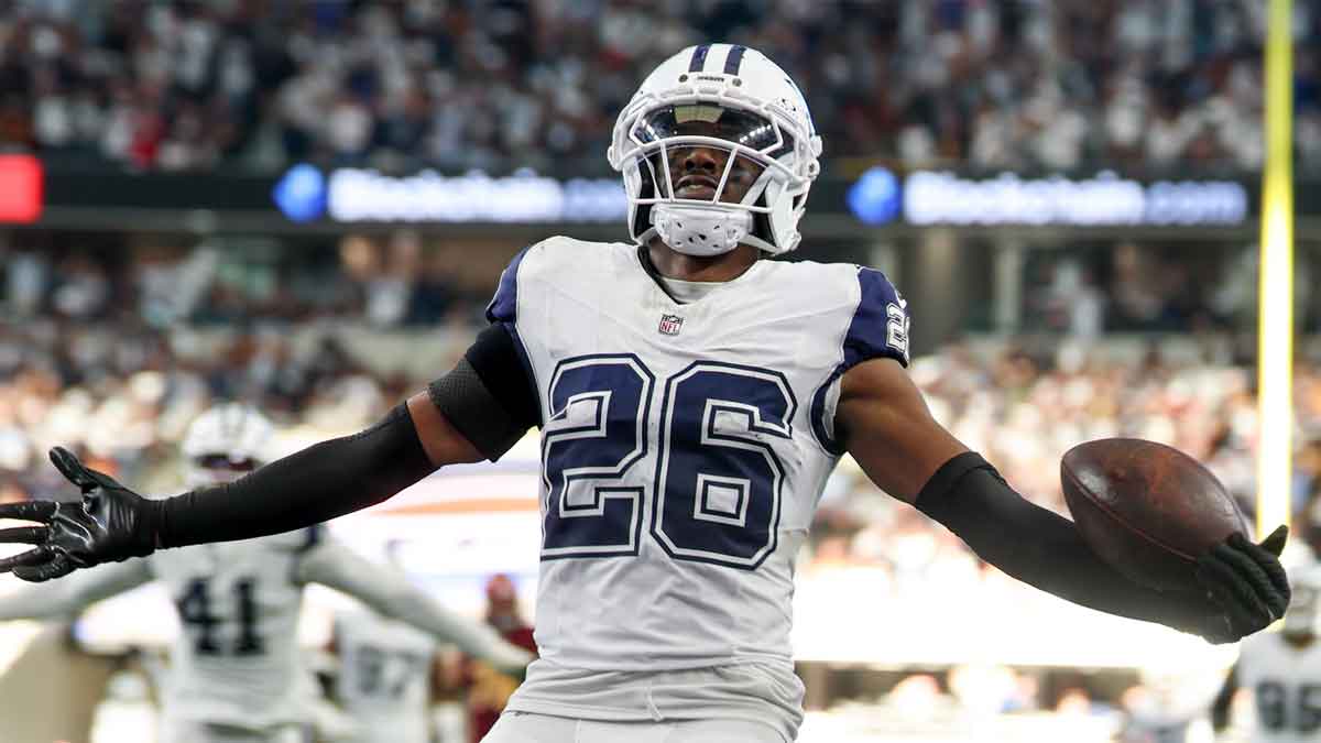 Dallas Cowboys cornerback Daron Bland (26) carries the ball after an interception for a touchdown against the Washington Commanders during the third quarter of the game at AT&T Stadium.