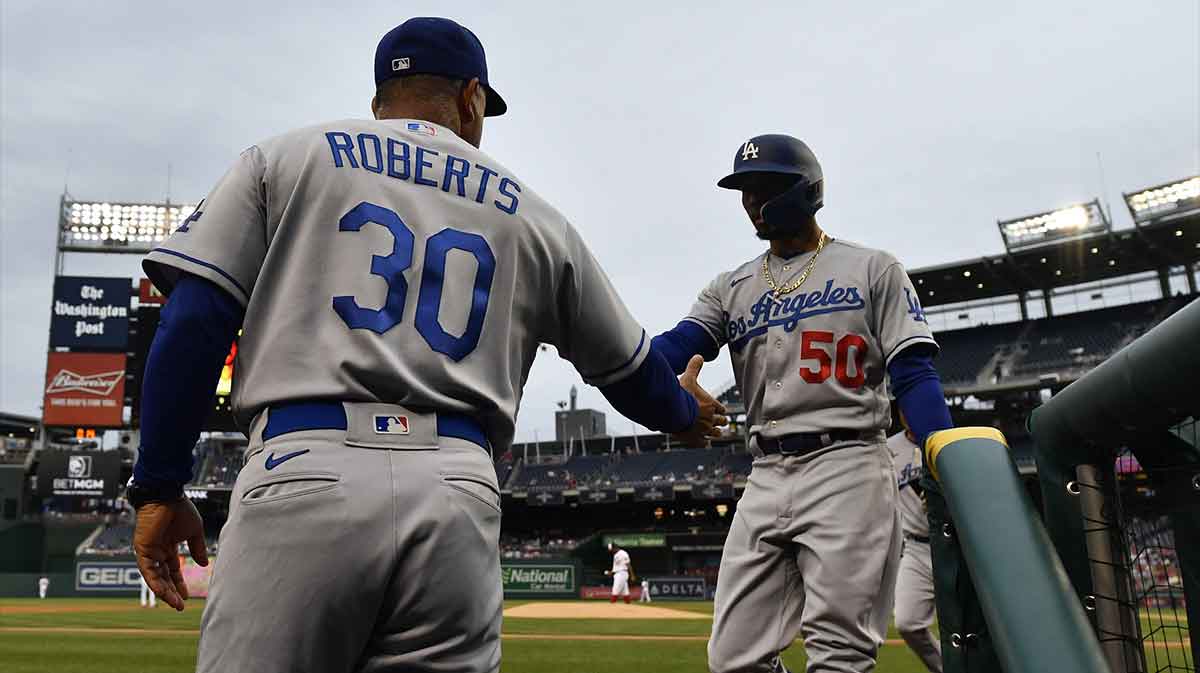 Los Angeles Dodgers right fielder Mookie Betts (50) is congratulated by manager Dave Roberts (30) after scoring against the Washington Nationals during the first inning at Nationals Park.