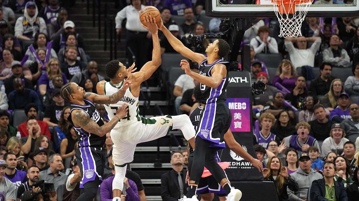 Sacramento Kings forward Keegan Murray (right) blocks a shot by Milwaukee Bucks forward Giannis Antetokounmpo (center) as forward DeMar DeRozan (left) defends during the fourth quarter at Golden 1 Center.