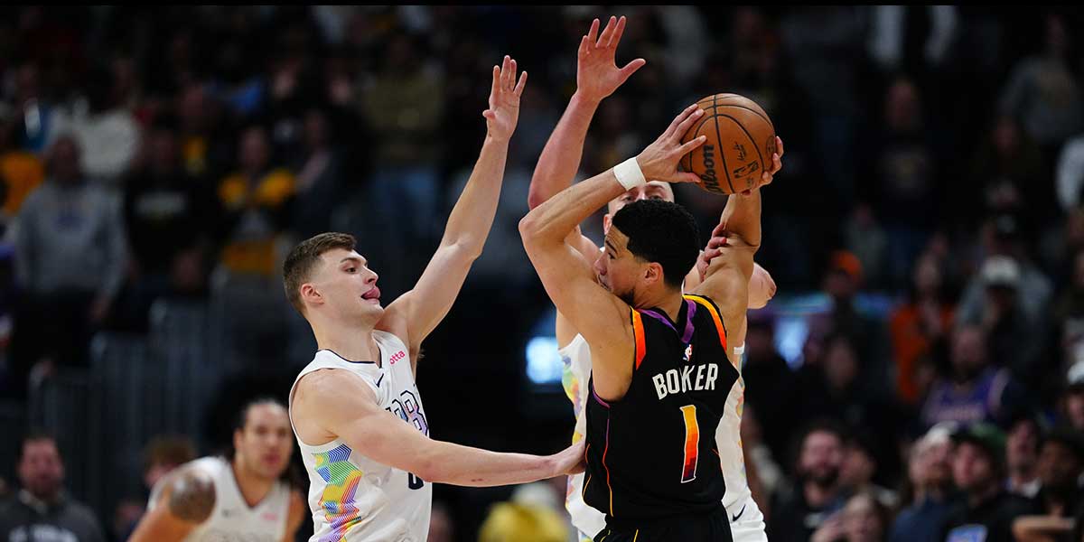 Denver Nuggets guard Christian Braun (0) and Denver Nuggets center Nikola Jokic (15) defend on Phoenix Suns guard Devin Booker (1) in the second half at Ball Arena.