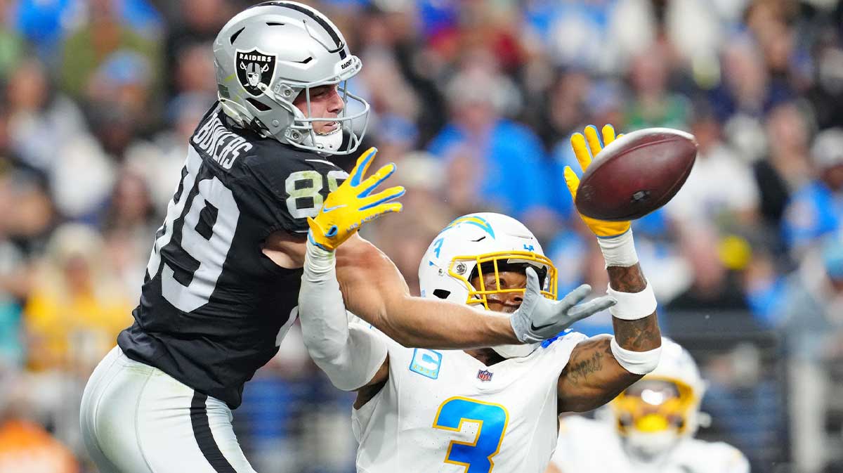 Las Vegas Raiders tight end Brock Bowers (89) and Los Angeles Chargers safety Derwin James Jr. (3) reach for a pass during the fourth quarter at Allegiant Stadium.