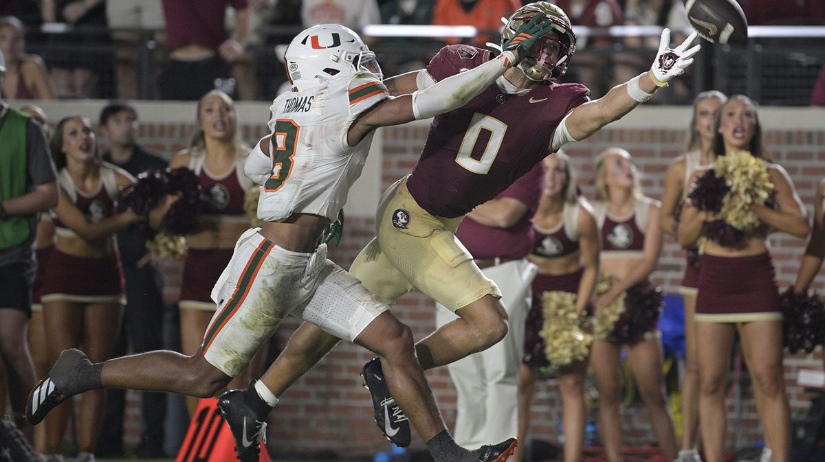 Florida State Seminoles wide receiver Duce Robinson reaches for a pass against Miami Hurricanes defensive back Jakobe Thomas (8) during the second half at Doak S. Campbell Stadium.