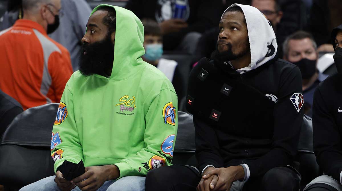 Brooklyn Nets guard James Harden (left) and forward Kevin Durant (right) sit on the bench in the first half against the Detroit Pistons at Little Caesars Arena