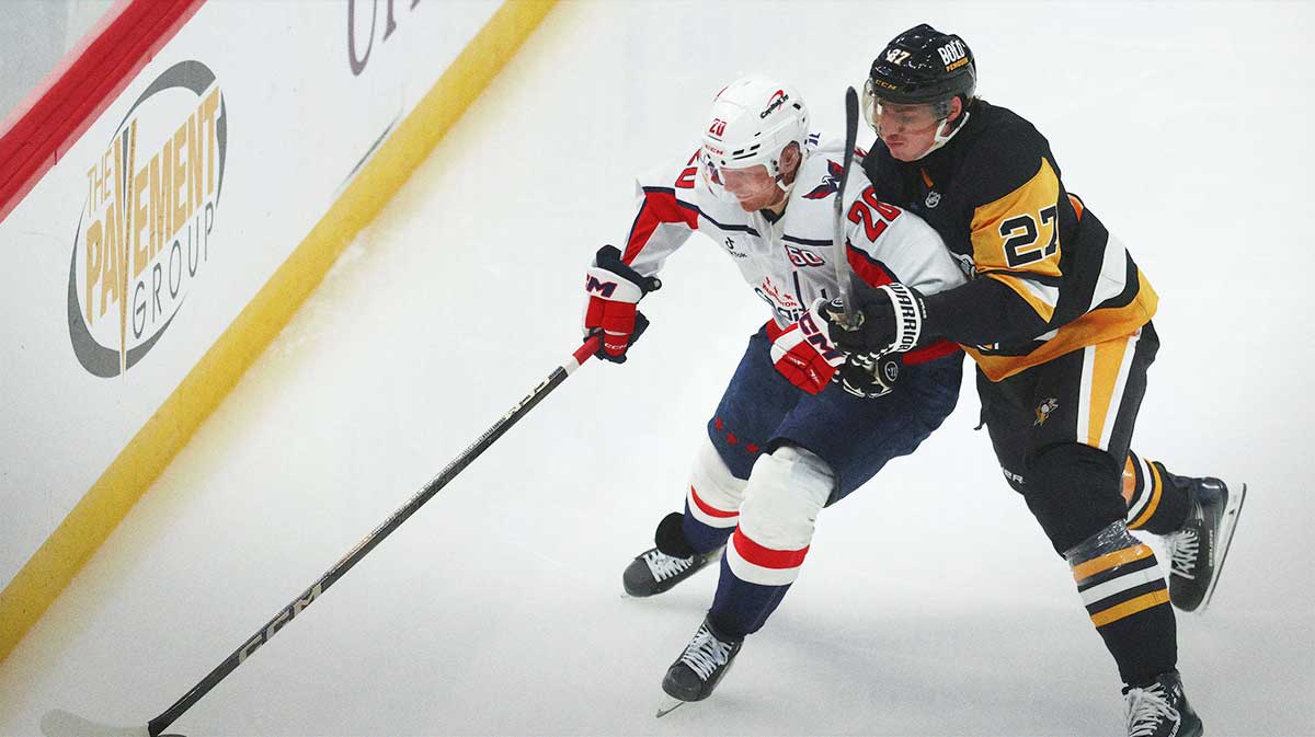 Washington Capitals center Lars Eller (20) over the puck against Pittsburgh Penguins defenseman Ryan Graves (27) during the third period at PPG Paints Arena.
