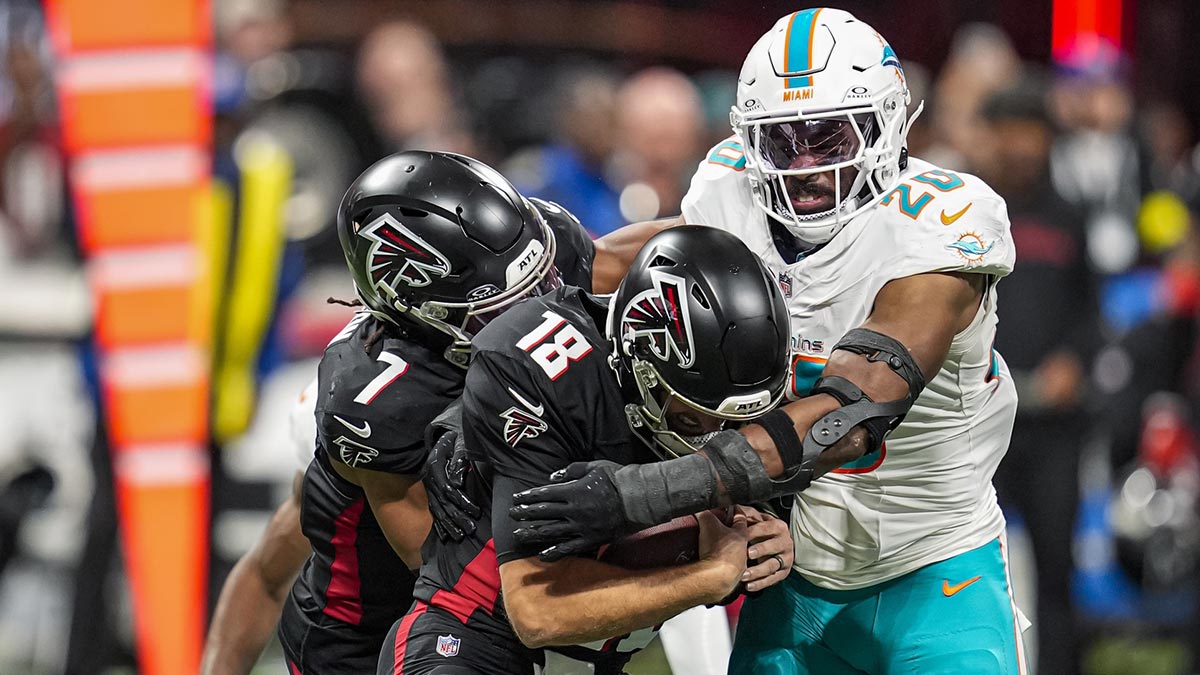 Miami Dolphins linebacker Jordyn Brooks (20) sacks Atlanta Falcons quarterback Kirk Cousins (18) during the first half at Mercedes-Benz Stadium.