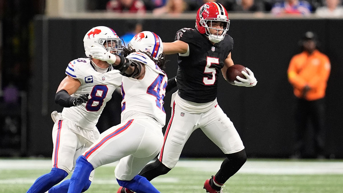 Atlanta Falcons wide receiver Drake London (5) runs after the catch as Buffalo Bills linebacker Terrel Bernard (8) and linebacker Dorian Williams (42) defend during the first half of a game at Mercedes-Benz Stadium.