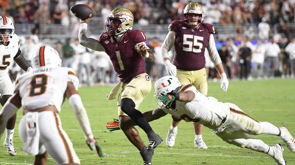 Florida State Seminoles quarterback Tommy Castellanos (1) throws against Miami Hurricanes defensive lineman Akheem Mesidor (3) during the second half at Doak S. Campbell Stadium.