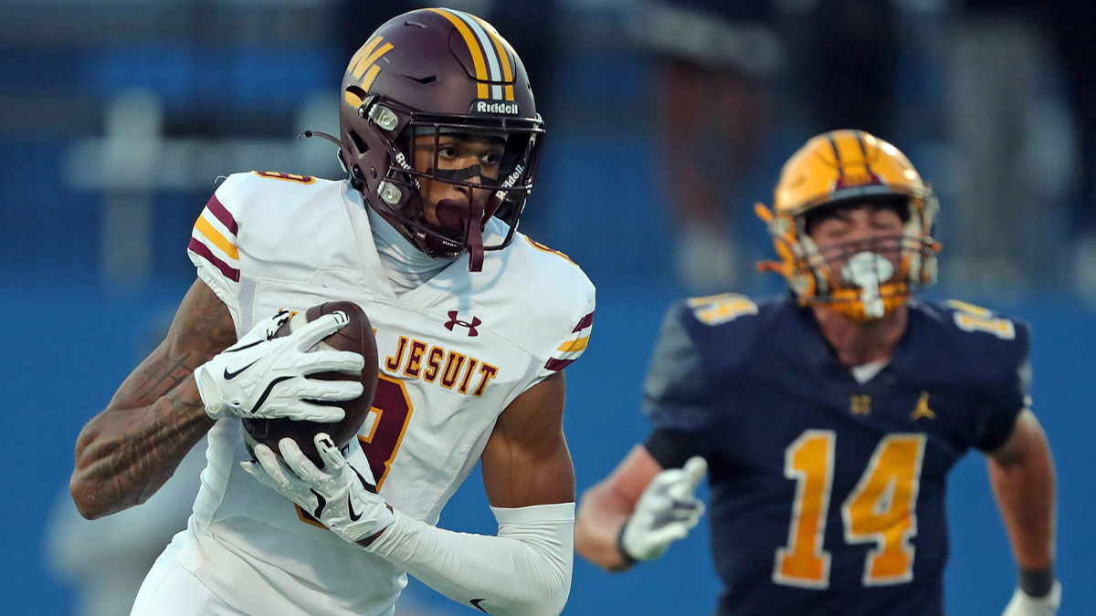 Walsh Jesuit wide receiver Milan Parris (8) scores a touchdown ahead of Saint Ignatius defensive back Anthony Anghilante (14) during the first half of a high school football game at Don Shula Stadium, Sept. 12, 2025, in University Heights, Ohio.