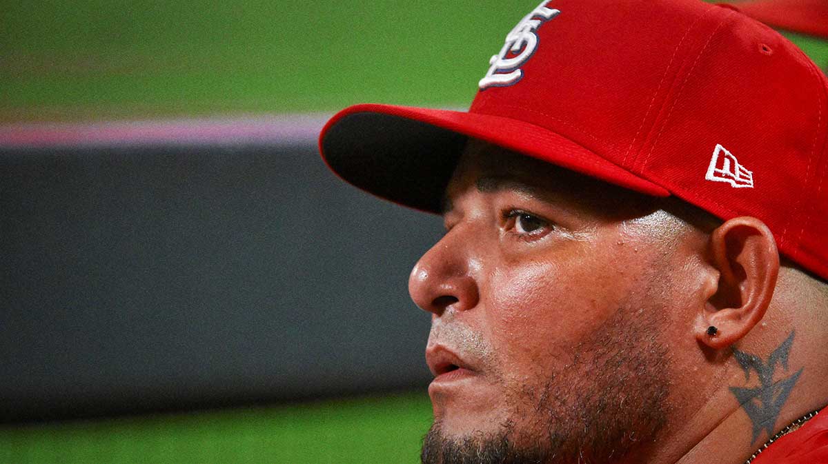 St. Louis Cardinals guest coach Yadier Molina (4) looks on from the dugout during the ninth inning against the Chicago Cubs at Busch Stadium.