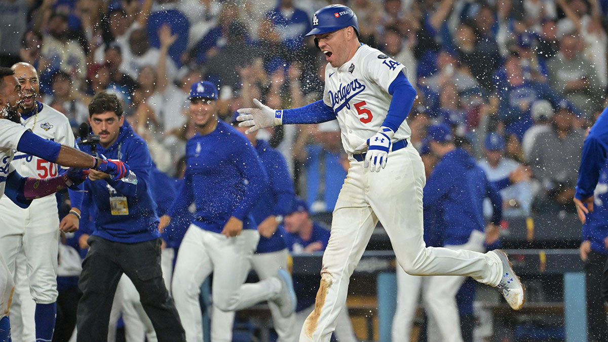 Los Angeles Dodgers first baseman Freddie Freeman (5) celebrates with teammates after hitting a walk off home run against the Toronto Blue Jays in the eighteenth inning during game three of the 2025 MLB World Series at Dodger Stadium.