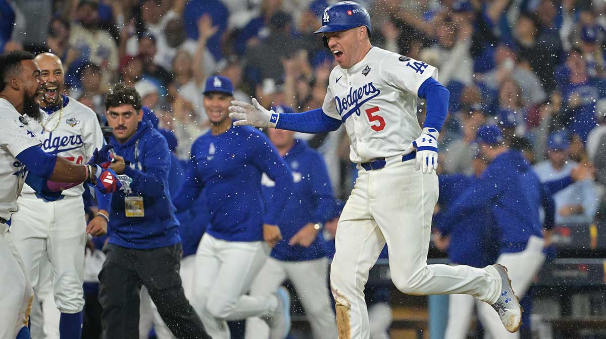 Los Angeles Dodgers first baseman Freddie Freeman (5) celebrates with teammates after hitting a walk off home run against the Toronto Blue Jays in the eighteenth inning during game three of the 2025 MLB World Series at Dodger Stadium.