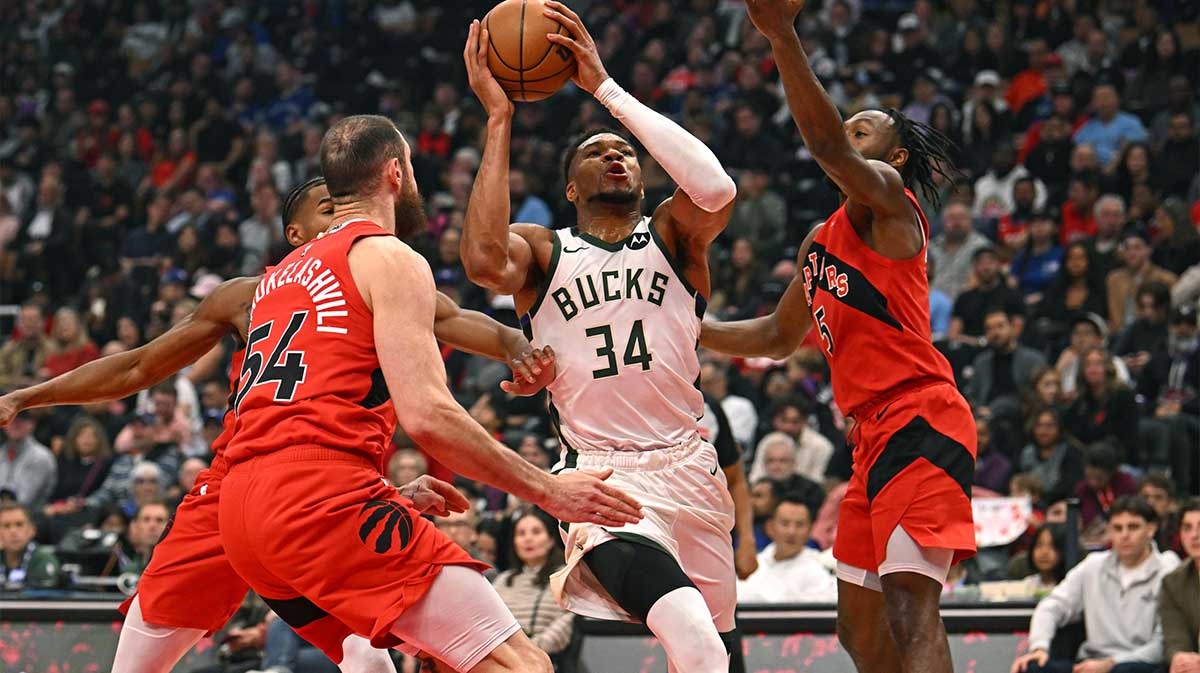 Milwaukee Bucks forward Giannis Antetokounmpo (34) is defended by Toronto Raptors forward Sandro Mamukelashvili (54) and guard Immanuel Quickley (5) in the first quarter at Scotiabank Arena.