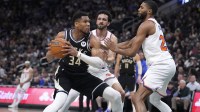 Milwaukee Bucks forward Giannis Antetokounmpo (34) puts up a shot against New York Knicks guard Landry Shamet (44) and New York Knicks forward Mikal Bridges (25) in the first half at Fiserv Forum.