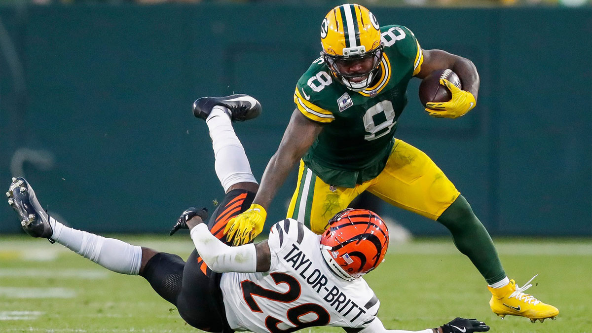 Green Bay Packers running back Josh Jacobs (8) stiff-arms Cincinnati Bengals cornerback Cam Taylor-Britt (29)