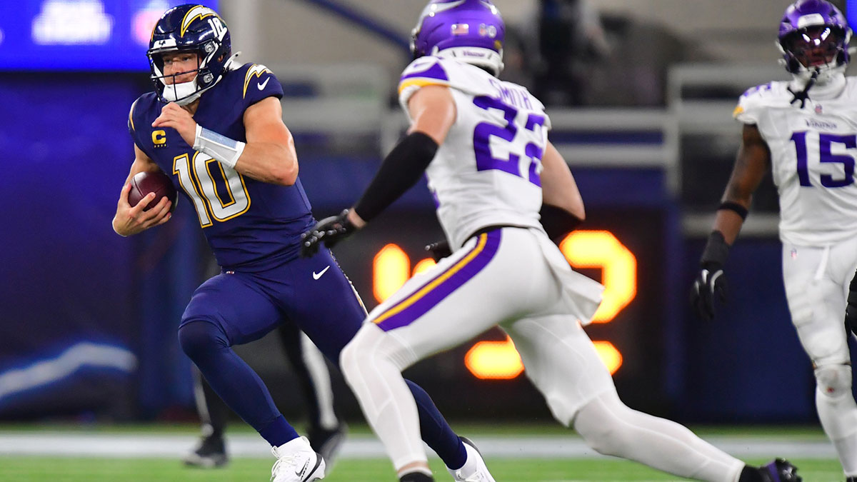 Los Angeles Chargers quarterback Justin Herbert (10) rushes the ball past Minnesota Vikings linebacker Blake Cashman (51) during the first half at SoFi Stadium. 