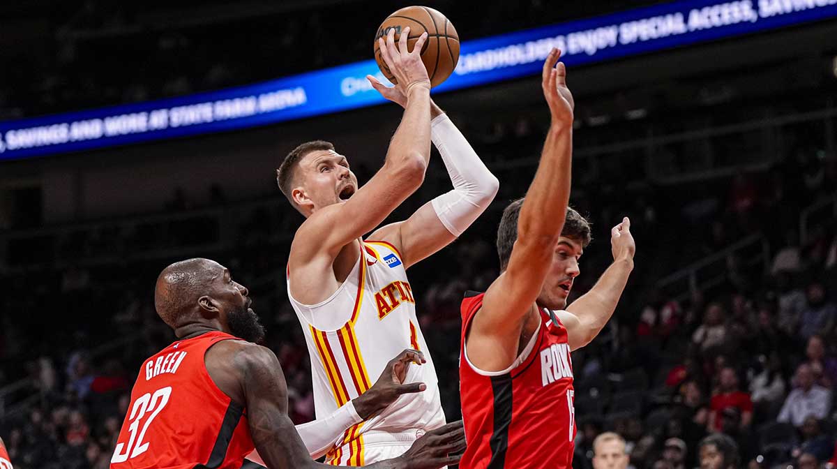 Atlanta Hawks center Kristaps Porzingis (8) goes to the basket between Houston Rockets forward Jeff Green (32) and guard Reed Sheppard (15) during the first half at State Farm Arena.