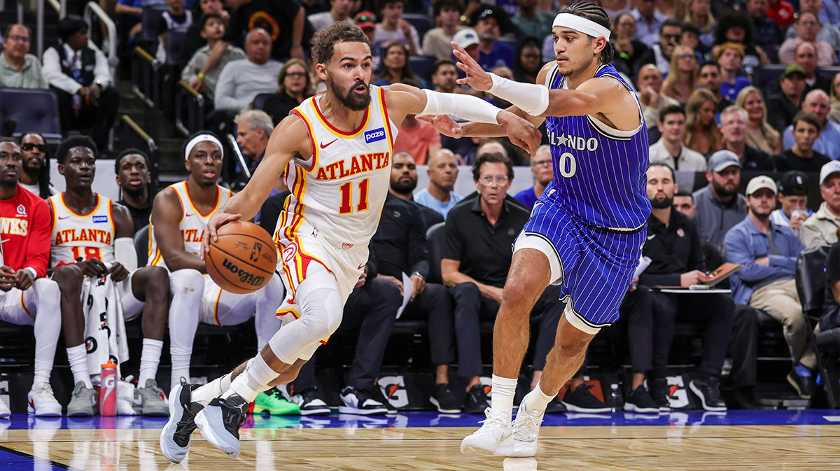 Hawks guard Trae Young (11) drives around Orlando Magic guard Anthony Black (0) during the second quarter at Kia Center with contract extension in the background