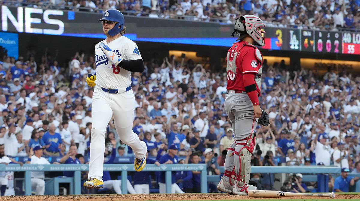 Los Angeles Dodgers first baseman Kike Hernandez (8) crosses home plate to score in the fourth inning as Cincinnati Reds catcher Jose Trevino (35) watches at Dodger Stadium.
