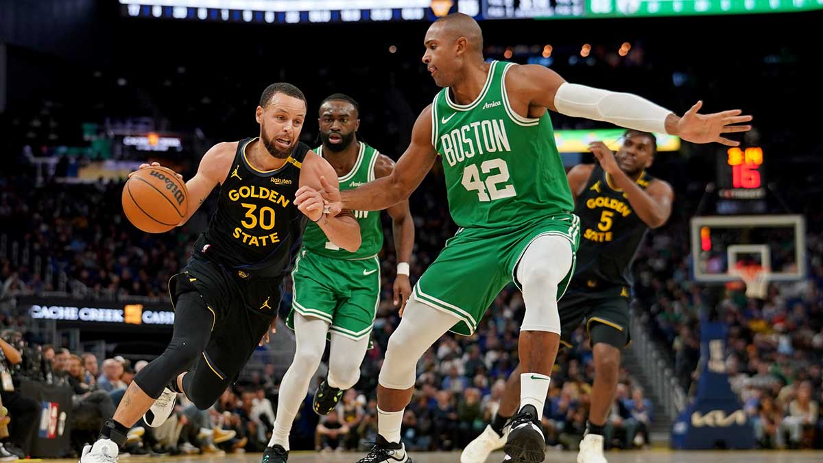 Golden State Warriors guard Stephen Curry (30) dribbles the ball next to Boston Celtics center Al Horford (42) in the third quarter at the Chase Center.