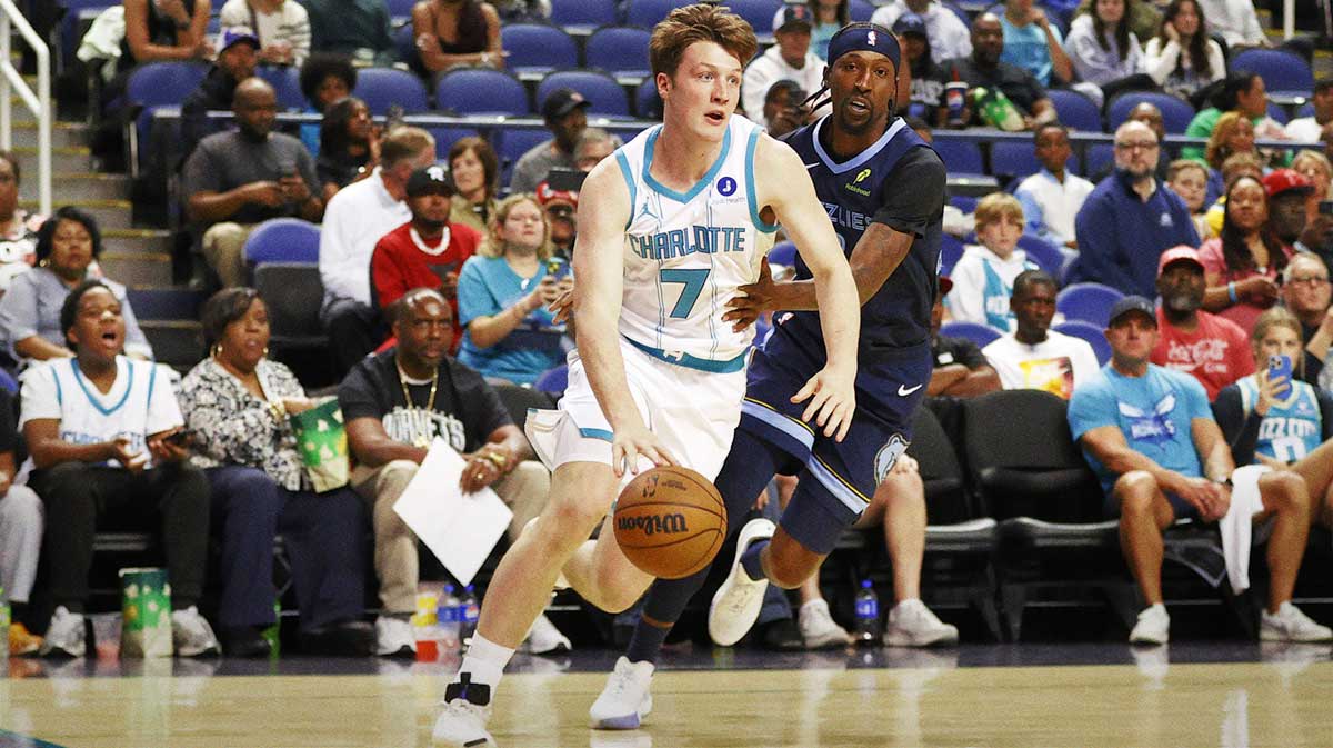 Charlotte Hornets guard/forward Kon Knueppel (7) drives past Memphis Grizzlies guard Kentavious Caldwell-Pope (3) during first quarter action at First Horizon Coliseum.