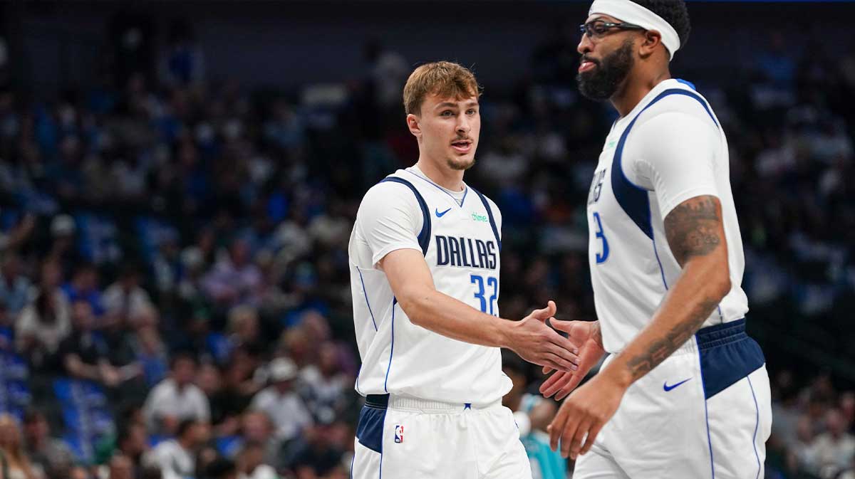 Dallas Mavericks forward Cooper Flagg (32) low fives forward/center Anthony Davis (3) in the first half of game against the Charlotte Hornets at American Airlines Center.