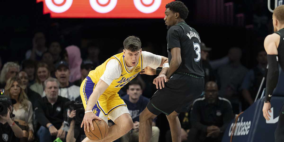 Los Angeles Lakers forward Jake LaRavia (12) dribbles towards the basket as Minnesota Timberwolves forward Jaden McDaniels (3) plays defense in the first half at Target Center.