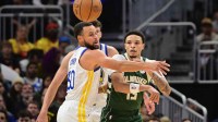Milwaukee Bucks guard Ryan Rollins (13) passes the ball away from Golden State Warriors guard Stephen Curry (30) in the first quarter at Fiserv Forum.