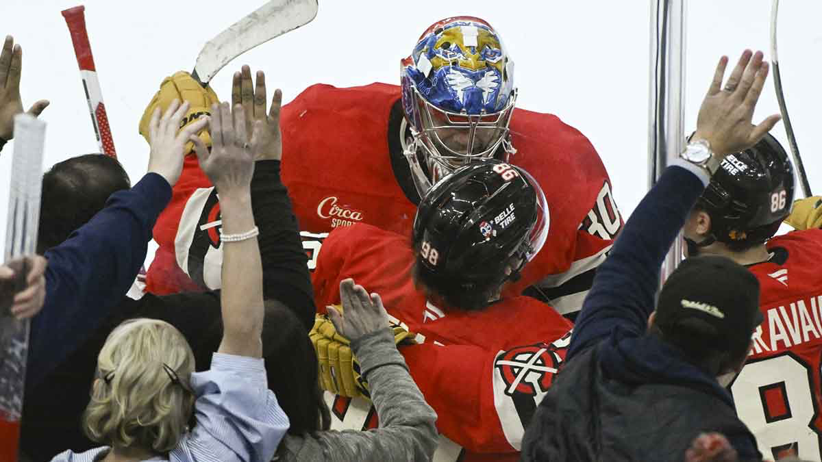 Chicago Blackhawks center Connor Bedard (98) celebrates with goaltender Spencer Knight (30) after scoring the winning goal.