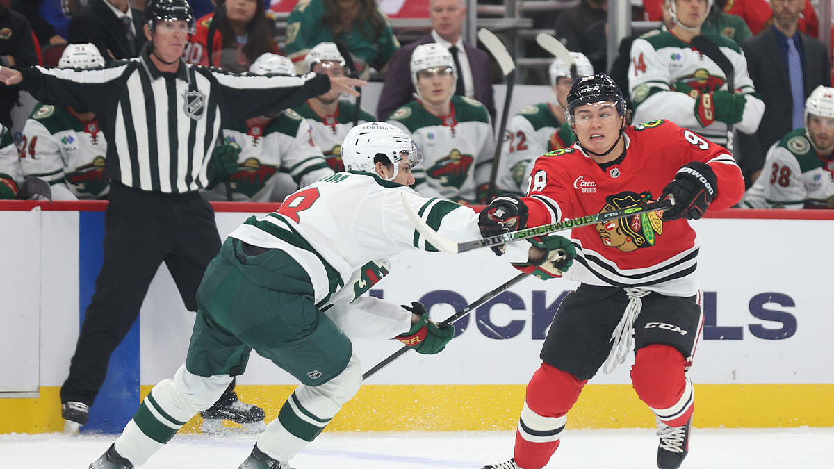 Chicago Blackhawks center Connor Bedard (98) and Minnesota Wild defenseman Zeev Buium (8) battle for control of the puck during the first period at United Center
