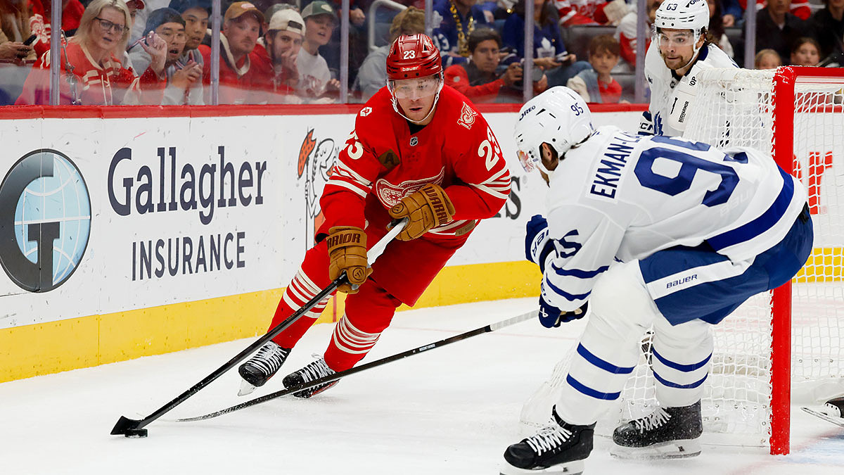 Detroit Red Wings left wing Lucas Raymond (23) skates with the puck defended by Toronto Maple Leafs defenseman Oliver Ekman-Larsson (95) in the second period at Little Caesars Arena
