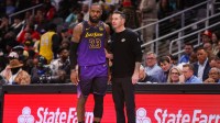 Los Angeles Lakers forward LeBron James (23) talks to head coach JJ Redick against the Atlanta Hawks in the second quarter at State Farm Arena.