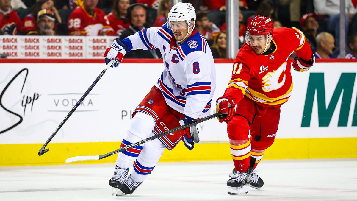 New York Rangers center J.T. Miller (8) and Calgary Flames center Mikael Backlund (11) battles for the puck during the third period at Scotiabank Saddledome.