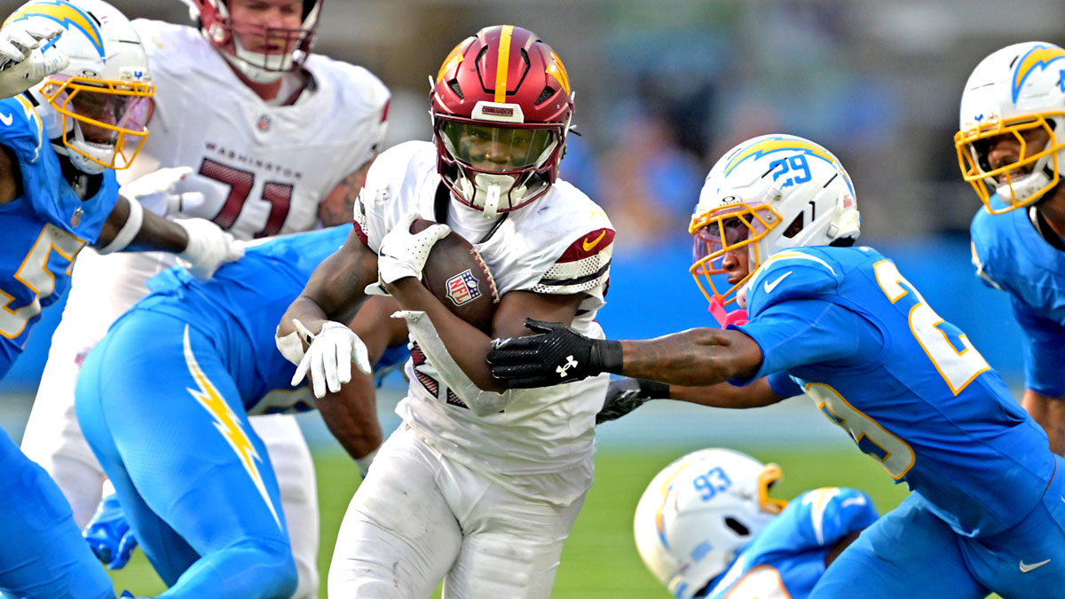 Washington Commanders running back Jacory Croskey-Merritt (22) runs past Los Angeles Chargers defense at SoFi Stadium.